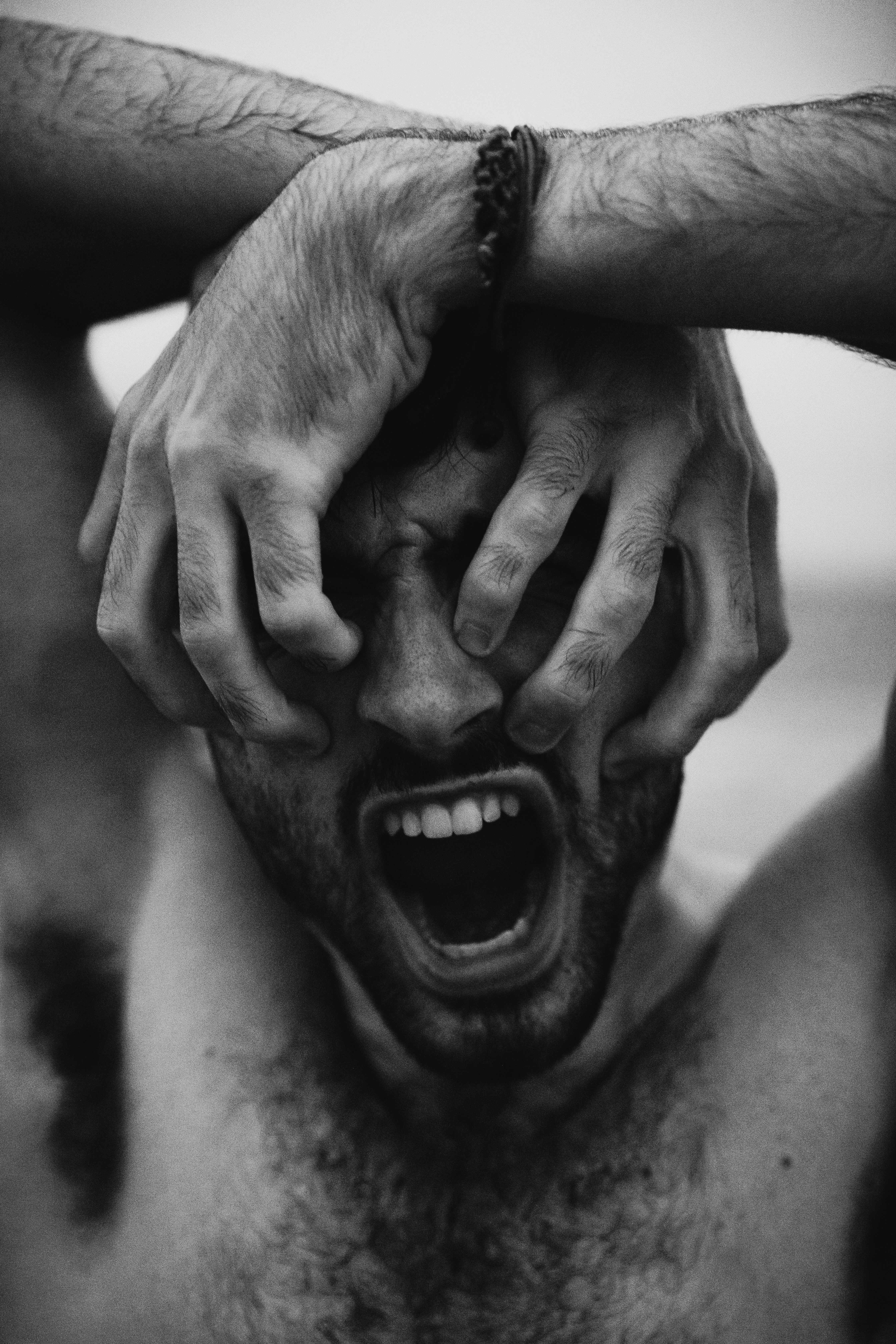 grayscale photo of man touching his face